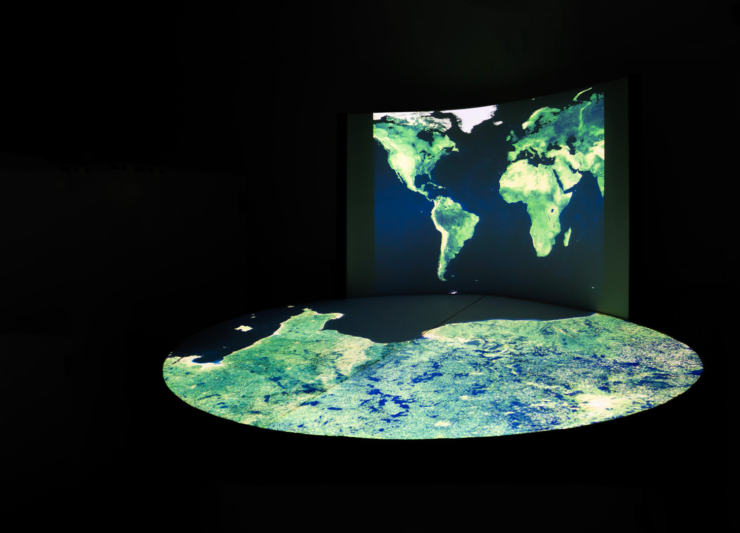 Schéma pour expliquer le processus NormanDisplay. Quatre personnes sont autour d'une table sur laquelle est posée une maquette en 3D du territoire. Ils sont en pleine concertation. Les mots-clés suivants sont écrits : Représenter, comprendre, échanger et participer pour agir.