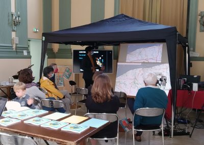 Un atelier de concertation en petit comité se déroule autour de la maquette de la Communauté de Communes de la Côte d'Albâtre. Des participants discutent, assis face à la maquette.