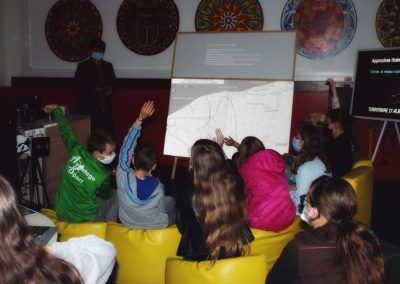 L'équipe Up mène un atelier dans un collège en Normandie avec la maquette interactive hypermobile de la Communauté de Communes de la Côte d'Albâtre. Des collégiens lèvent la main pour participer à la concertation.